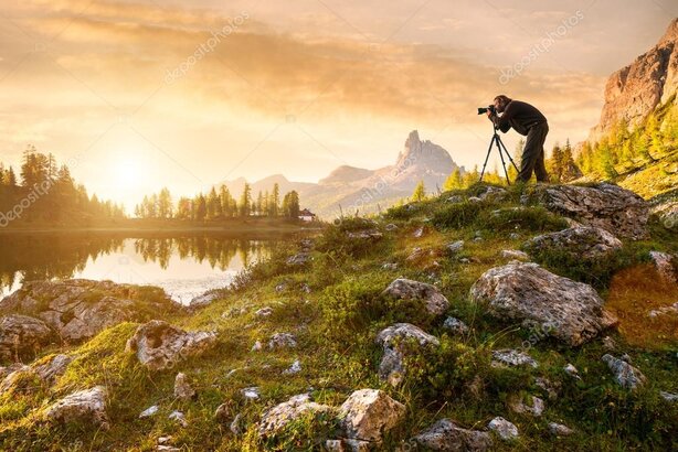 Fotografo con treppiede che scatta all’alba sulle colline della Val d’Orcia
